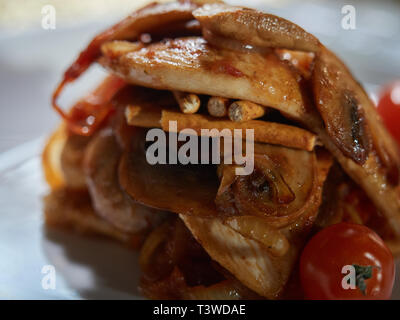 Les petites coupes de viande cuite avec les champignons et les oignons frits sont servis à la table pour le dîner. Banque D'Images