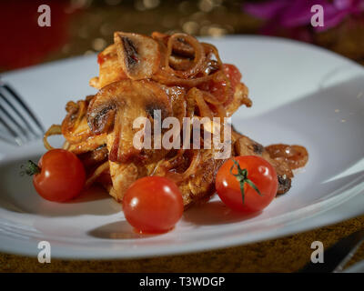 Les petites coupes de viande cuite avec les champignons et les oignons frits sont servis à la table pour le dîner. Banque D'Images