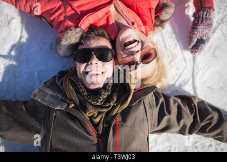 Caucasian couple in sunglasses smiling in snow Banque D'Images