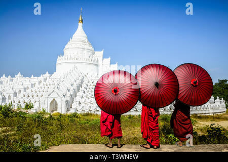 Les moines d'Asie temple historique de visualisation sous les parasols, Mingun, Mandala, Myanmar Banque D'Images