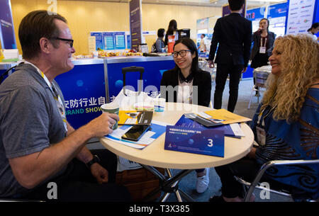 (190412) -- LAS VEGAS, 12 avril 2019 (Xinhua) -- Neytiri Qiu (C), représentant de Shenzhen Zhongxi Security Co. Ltd, parle avec les acheteurs à l'International Security Conference and Exposition (ISC West) de Las Vegas, aux États-Unis, le 10 avril 2019. Les sociétés de sécurité chinoises sont à la recherche de plus d'opportunités commerciales sur le marché américain à la Conférence et Exposition internationale de sécurité ici. Un total de 154 entreprises chinoises, à partir de secteurs, y compris la surveillance, les maisons intelligentes, contrôle d'accès et la sécurité à la frontière, participent au salon annuel du mercredi au vendredi, th Banque D'Images