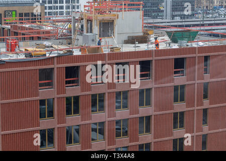 12 avril 2019, Bavaria, Munich : les travailleurs de la construction sont debout sur le toit non fini pour une nouvelle maison dans la capitale bavaroise. Photo : Peter Kneffel/dpa Banque D'Images