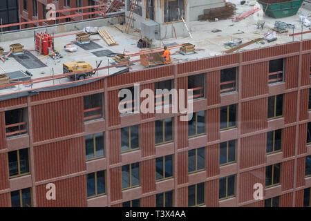 12 avril 2019, Bavaria, Munich : les travailleurs de la construction sont debout sur le toit non fini pour une nouvelle maison dans la capitale bavaroise. Photo : Peter Kneffel/dpa Banque D'Images
