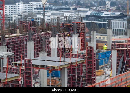 12 avril 2019, Bavaria, Munich : les travailleurs de la construction sont debout sur le toit non fini pour une nouvelle maison dans la capitale bavaroise. Photo : Peter Kneffel/dpa Banque D'Images