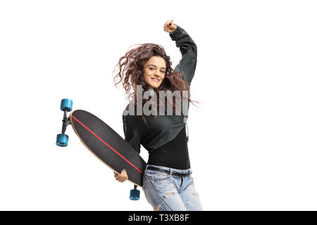 Happy teen girl avec un longboard jumping isolé sur fond blanc Banque D'Images