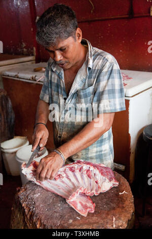 Butcher transformant un carcasse de chèvre, Manning, marché de Pettah, Colombo, Sri Lanka Banque D'Images