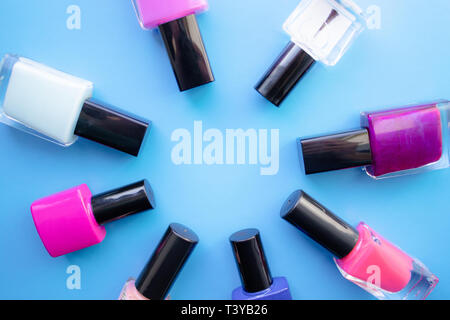 Bouteilles de vernis à ongles. Un groupe de vernis brillant sur un fond bleu. Avec l'espace vide au milieu. Vue de dessus Banque D'Images