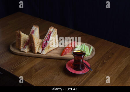 Tranches de cheddar et toast saucisses tomates concombre le thé préparé pour le petit déjeuner Banque D'Images