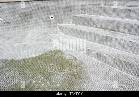 Le jointoiement du carrelage mosaïque en cours sur une fuite dans une piscine. Banque D'Images