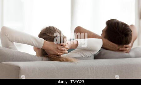Vue arrière peaceful young couple relaxing on sofa together Banque D'Images