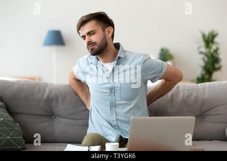 Fatigué homme frustré souffrant de douleurs, le massage dos Banque D'Images