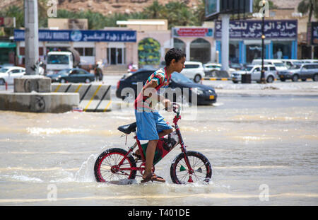 Nizwa, Oman, le 9 avril 2016 : son vélo dans l'eau d'une inondation Banque D'Images