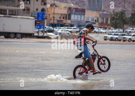 Nizwa, Oman, le 9 avril 2016 : son vélo dans l'eau d'une inondation Banque D'Images