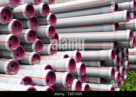 De nombreux tubes en plastique long empilées prête pour la construction d'un système d'approvisionnement en eau et d'irrigation agricole sur le motif Banque D'Images