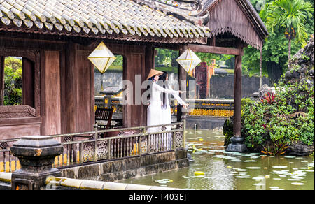 Deux jeunes femmes portant des costumes nationaux traditionnels, ao dai, dans la ville impériale, Hue, Vietnam Banque D'Images