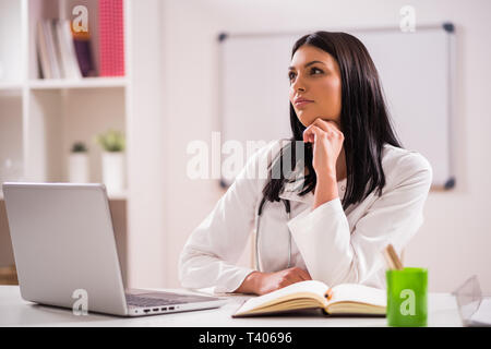 Portrait de jeune médecin pensif dans son bureau. Banque D'Images