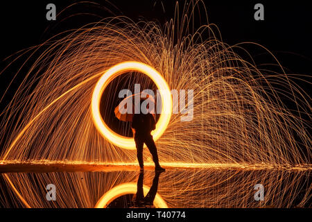 Peinture de lumière. Affichage pyrotechnique de nuit avec le reflet de l'eau Banque D'Images