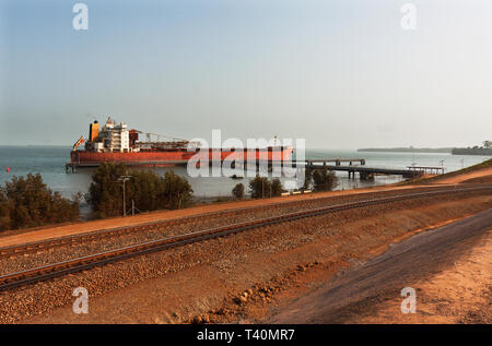 Opérations portuaires pour la gestion et le transport de minerai de fer. L'ensemble de train de minerai de fer à boucle TSV navire amarré à quai avant de passer à l'aire de chargement. Banque D'Images