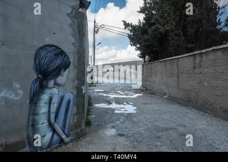 Une fille de graffiti se cacher le long d'une rue latérale dans le camp Aida, Bethléem, Cisjordanie, Palestine, 11/02/19 Banque D'Images
