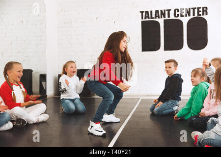 Les enfants à l'école de danse. Ballet, hip hop, street, funky et danseurs modernes sur fond de studio. Les enfants montrant l'élément aérobique. Les adolescents de style hip-hop. Sport, Fitness and Lifestyle concept. Banque D'Images