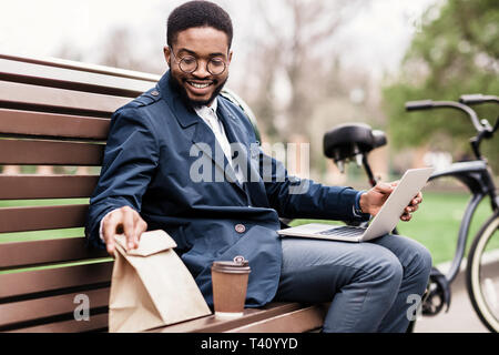 Temps pour une collation. Businessman having lunch avec son vélo à proximité Banque D'Images