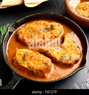 Close up of curry de poisson dans le moule sur une table en pierre noire. Le style indien de la nourriture. Les fruits de mer. Banque D'Images