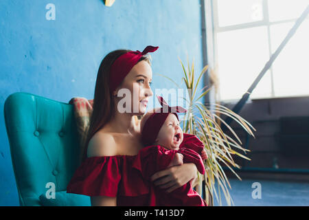 Jolie femme tenant un bébé nouveau-né dans ses bras. Banque D'Images