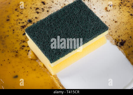 Dans l'éponge nettoyer une poêle Banque D'Images