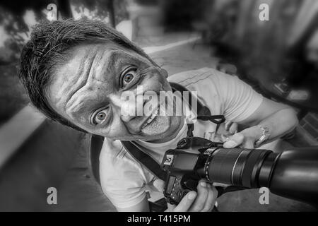 Close-up d'un journaliste / photographe avec appareil photo et le crazy face comique Banque D'Images