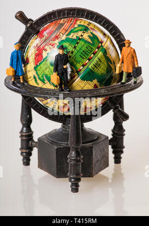 Voyageurs du Monde : figures miniatures sur un globe Banque D'Images