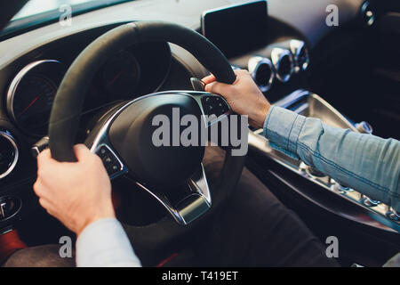 La conduite d'affaires moderne de luxe voiture en ville. Close up la main de l'homme sur la roue de la voiture. Banque D'Images