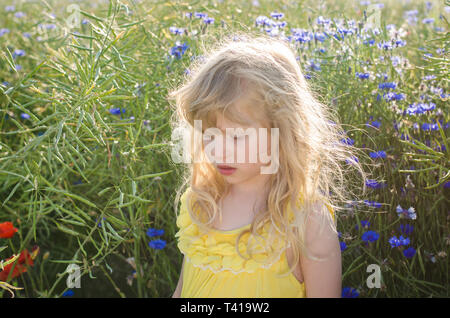 Adorable petite fille blonde en robe jaune Banque D'Images