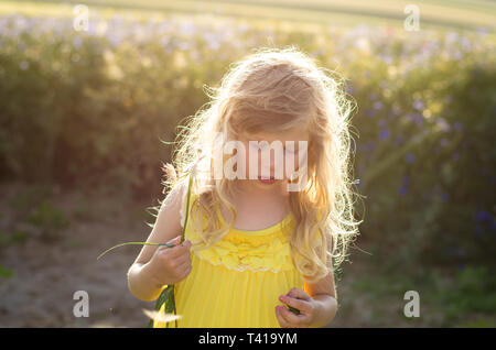 Adorable petite fille blonde en robe jaune Banque D'Images