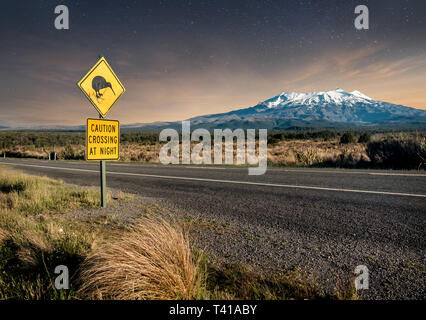 Kiwi crossing sign la nuit prochaine à Mount Ruapehu enneigé dans le parc national de Tongariro. Banque D'Images