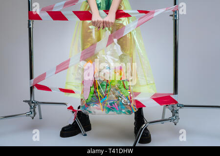 Des pailles et tasses. Close up of woman wearing black boots holding sac plein de pailles en plastique et tasses Banque D'Images