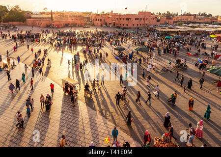 Marrakech, Maroc - 29 Apr 2016 : les touristes et les habitants sur la place Djemaa-el-Fna à Marrakech pendant le coucher du soleil. Banque D'Images