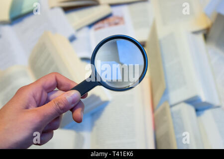 Loupe pour vérifier divers livres Banque D'Images
