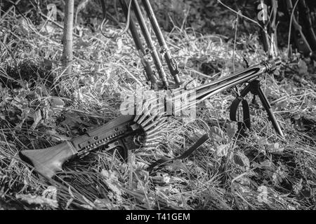 La Seconde Guerre mondiale, soldat d'infanterie de la Wehrmacht allemande d'armes nucléaires de l'armée. Mitrailleuse MG 42 sur le sol de la forêt en tranchée. La seconde guerre mondiale WW2 allemand de munitions. Une photo en noir Banque D'Images