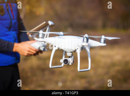 Drone d'exploitation homme battant par commande à distance dans le parc Banque D'Images