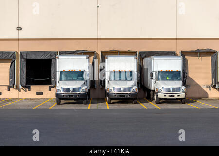 Les petites installations mobiles compact avec camions semi remorques pour boîte d'expédition et livraison locale dans la rangée debout à quais d'entrepôt en attente de chargement commerc Banque D'Images