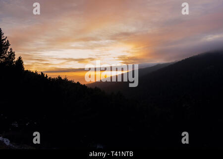 Coucher de soleil entre les montagnes et les forêts Banque D'Images