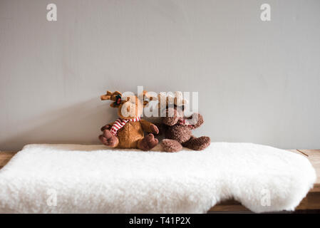 Deux orignaux children's soft toys assis sur un tapis blanc Banque D'Images