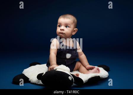 Joli Amérique baby boy posing in studio blue background Banque D'Images