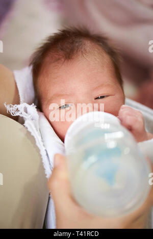 Bébé nouveau-né boire du lait en bouteille close up Banque D'Images