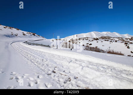 La route de Nida Plateau recouvert de neige. Dans l'arrière-plan les plus hauts sommets du Mont Psiloritis. Rethymnon, Crète, Grèce. Banque D'Images