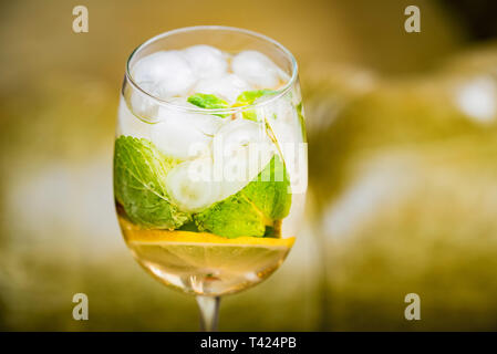 Verre avec de délicieux mojito maison sur l'arrière-plan flou Banque D'Images