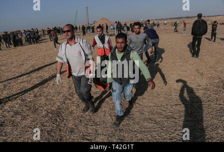 Les ambulanciers palestiniens sont vu porter un manifestant blessé lors de la manifestation près de la frontière avec Israël, à l'est de Khan Younis dans le sud de la bande de Gaza. Un adolescent palestinien a été tué par l'armée israélienne lors de la reprise des affrontements sur la frontière de Gaza, le ministère de la santé dans l'enclave palestinienne, a déclaré un porte-parole du ministère a déclaré Maysara Abu Shaloof, 15 ans, a été 'shot dans l'estomac par l'occupation israélienne) (à l'est de Jabalia," faisant référence à un site de démonstration dans le nord de Gaza. Banque D'Images