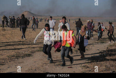 Les ambulanciers palestiniens sont vu porter un manifestant blessé lors de la manifestation près de la frontière avec Israël, à l'est de Khan Younis dans le sud de la bande de Gaza. Un adolescent palestinien a été tué par l'armée israélienne lors de la reprise des affrontements sur la frontière de Gaza, le ministère de la santé dans l'enclave palestinienne, a déclaré un porte-parole du ministère a déclaré Maysara Abu Shaloof, 15 ans, a été 'shot dans l'estomac par l'occupation israélienne) (à l'est de Jabalia," faisant référence à un site de démonstration dans le nord de Gaza. Banque D'Images