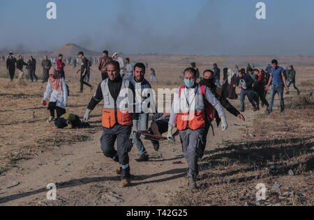 Les ambulanciers palestiniens sont vu porter un manifestant blessé lors de la manifestation près de la frontière avec Israël, à l'est de Khan Younis dans le sud de la bande de Gaza. Un adolescent palestinien a été tué par l'armée israélienne lors de la reprise des affrontements sur la frontière de Gaza, le ministère de la santé dans l'enclave palestinienne, a déclaré un porte-parole du ministère a déclaré Maysara Abu Shaloof, 15 ans, a été 'shot dans l'estomac par l'occupation israélienne) (à l'est de Jabalia," faisant référence à un site de démonstration dans le nord de Gaza. Banque D'Images