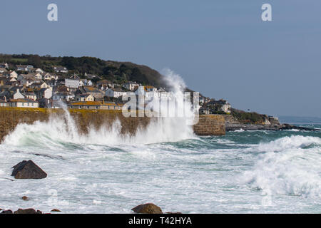 Mousehole, Cornwall, UK. 13 avr, 2019. Météo britannique. Des vents de 50km/h, et de grosses vagues batter le mur du port à Mousehole ce midi. Malgré le vent, il était toujours ensoleillé. Crédit : Simon Maycock/Alamy Live News Banque D'Images